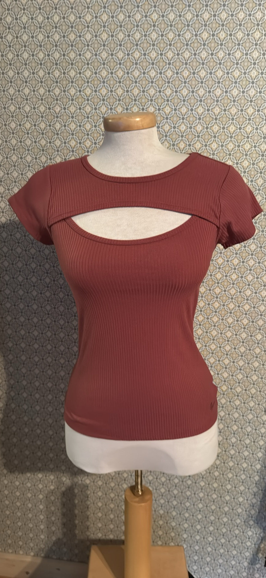 A short-sleeve ribbed knit top in a muted dusty rose or mauve colour