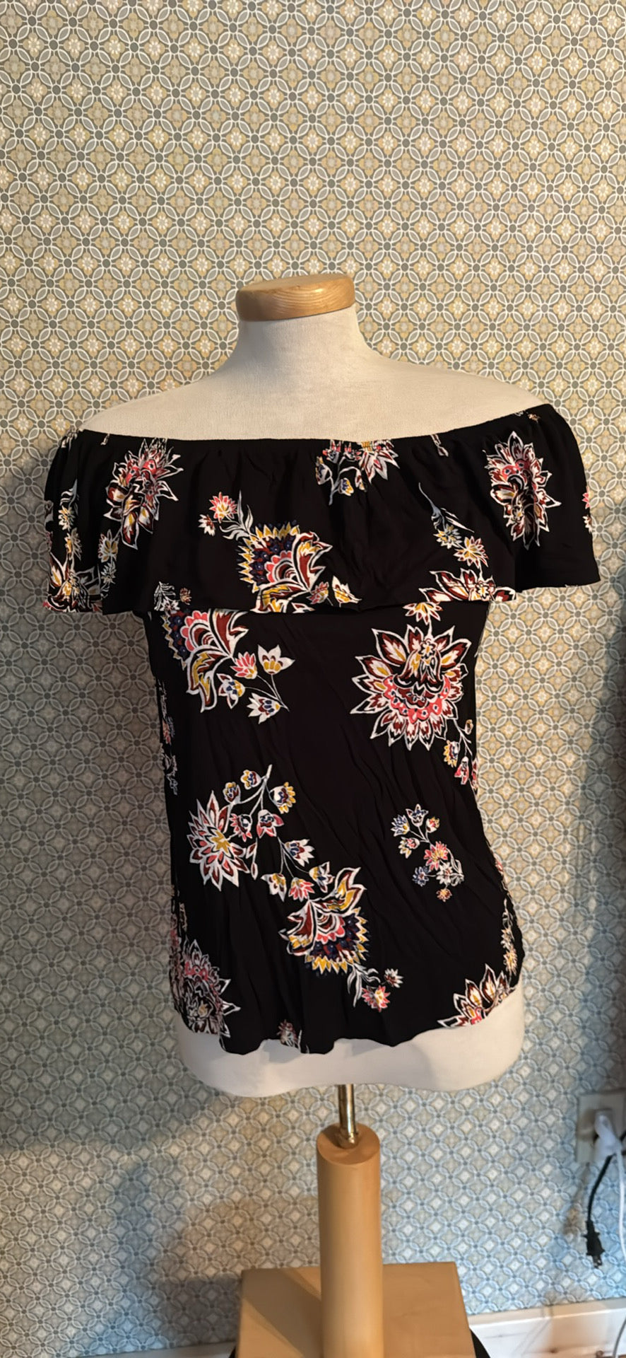 Black off-the-shoulder blouse with a colorful floral print