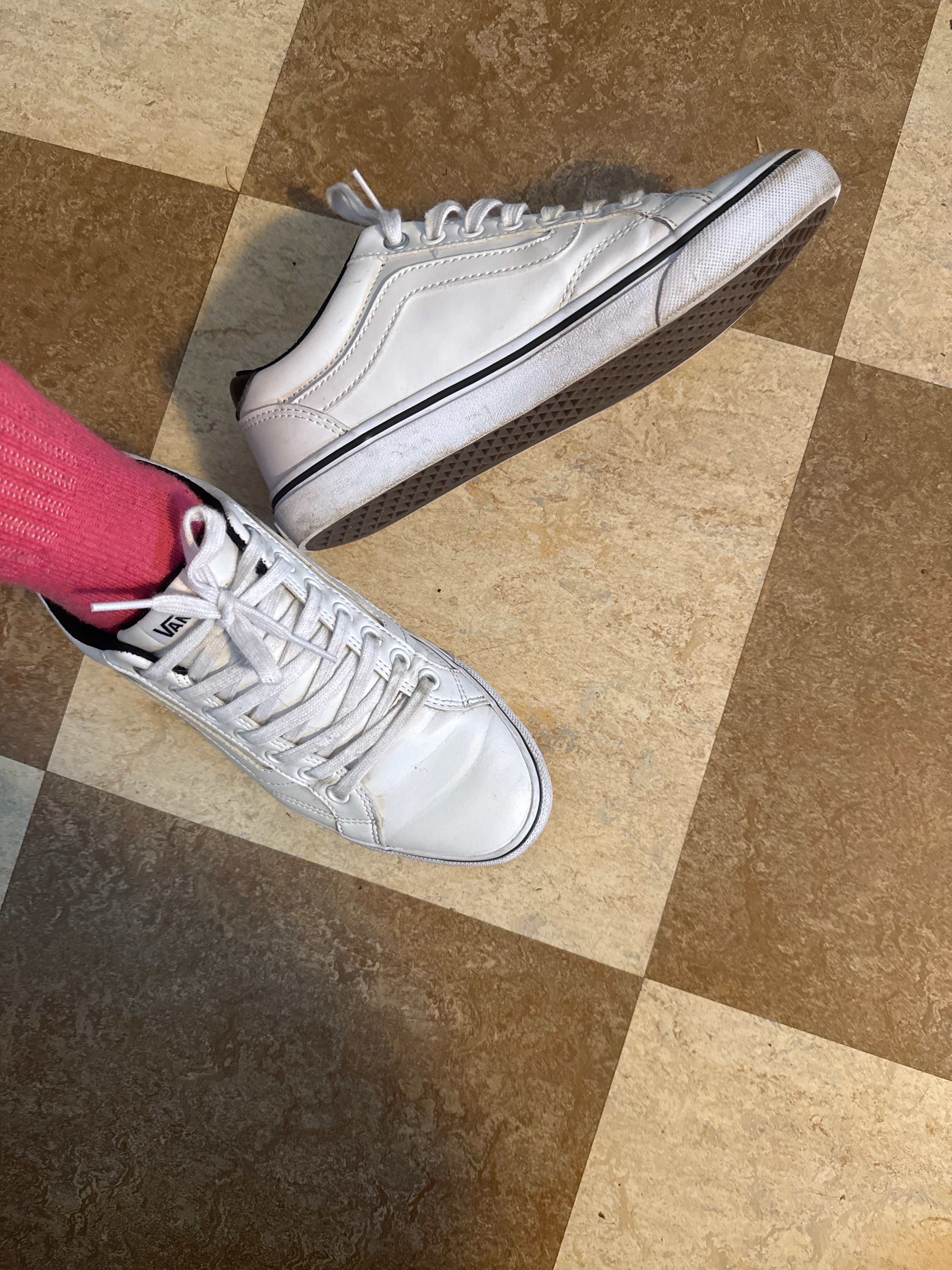 A pair of white leather Vans low-top sneakers with white laces