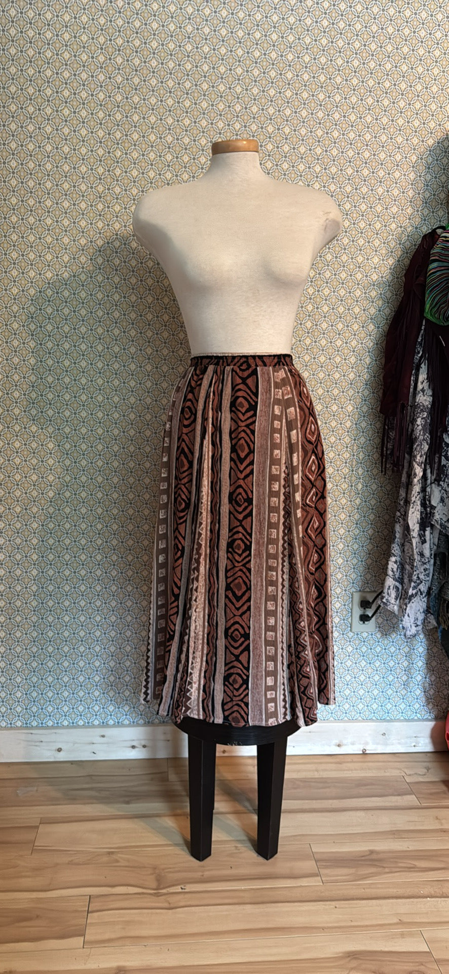 A patterned midi skirt displayed on a dress form mannequin 