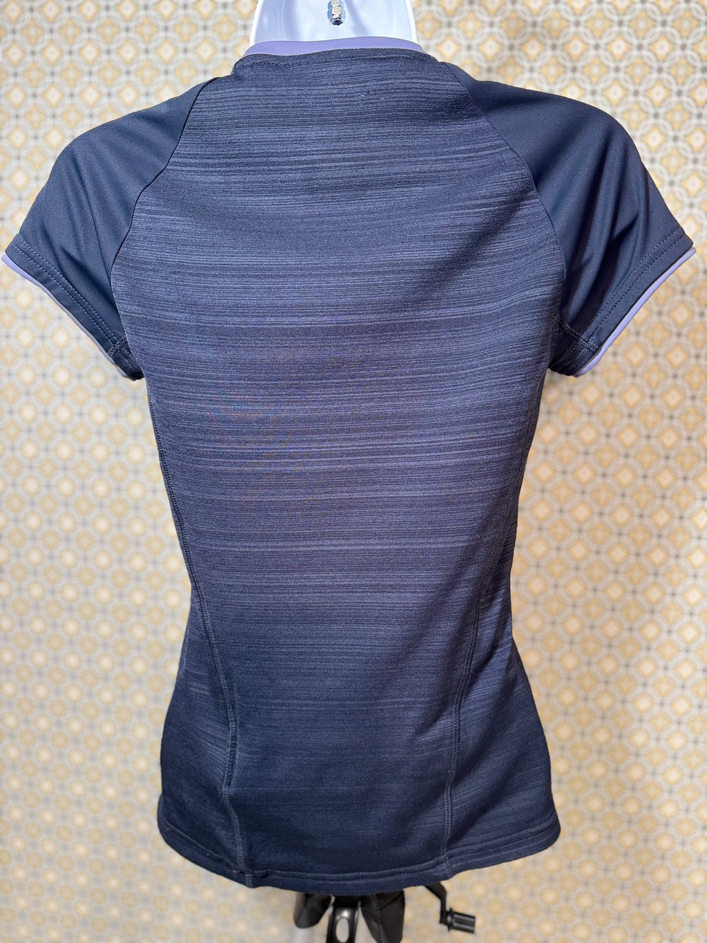 Back view of Navy blue, short sleeve, v-neck Adidas active wear women's fit top in extra small for sale by consignment.  