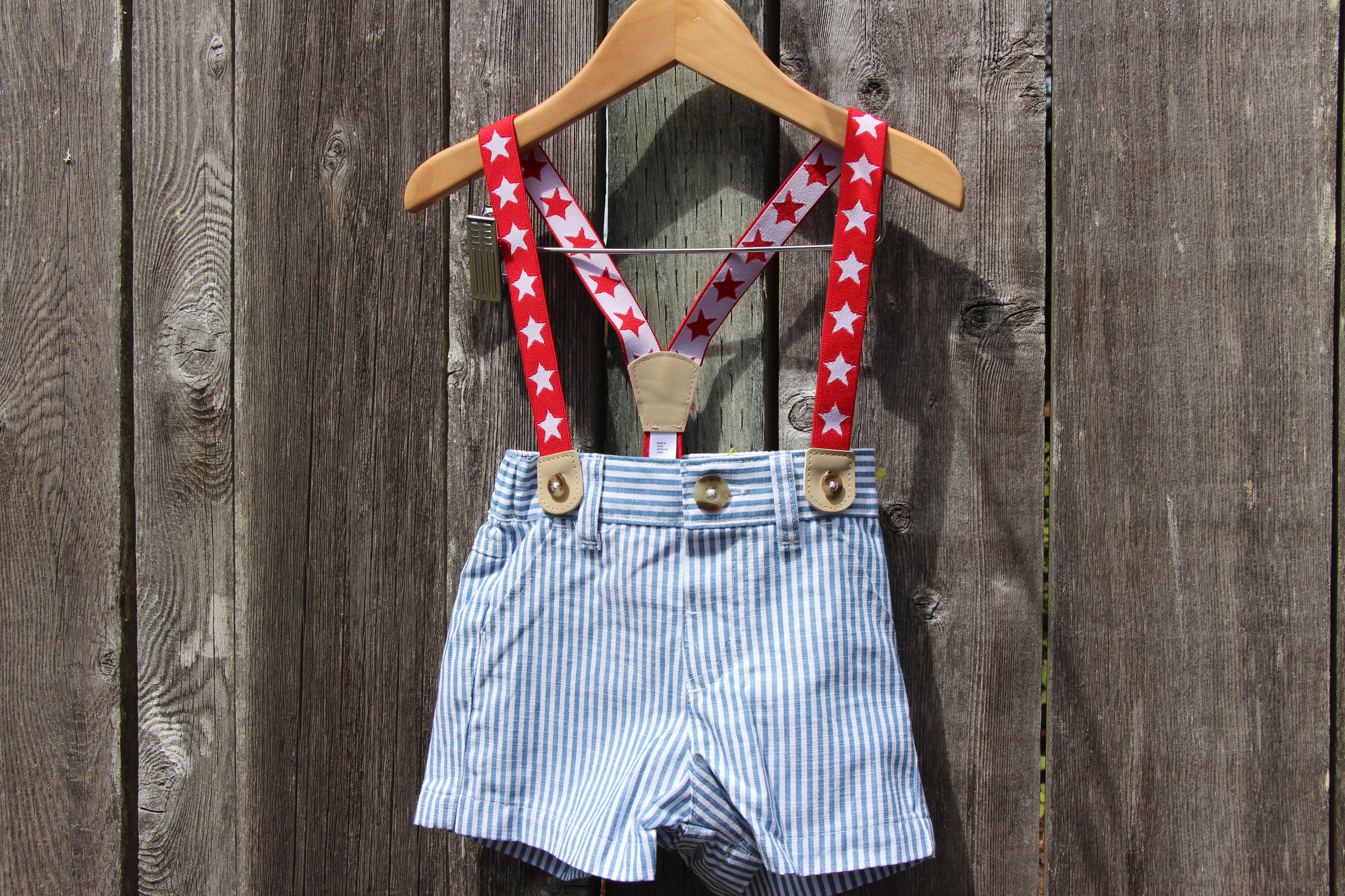 A pair of baby boy's shorts with red and white star-patterned suspenders 