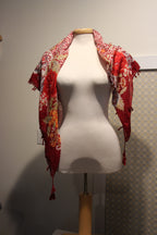 A consignment red floral and animal print scarf with tassels.