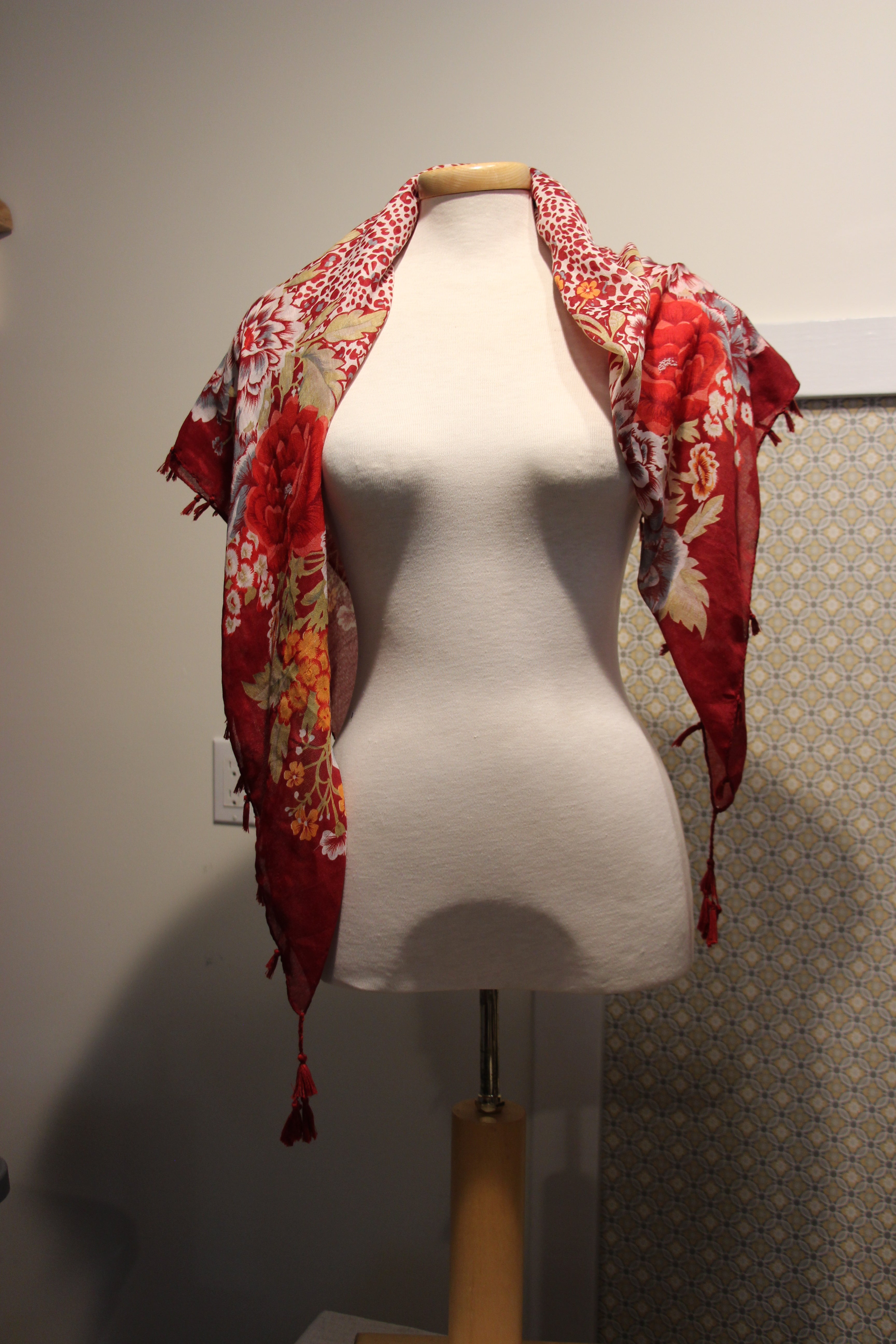 A consignment red floral and animal print scarf with tassels.
