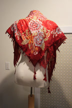 A consignment red floral and animal print scarf with tassels.