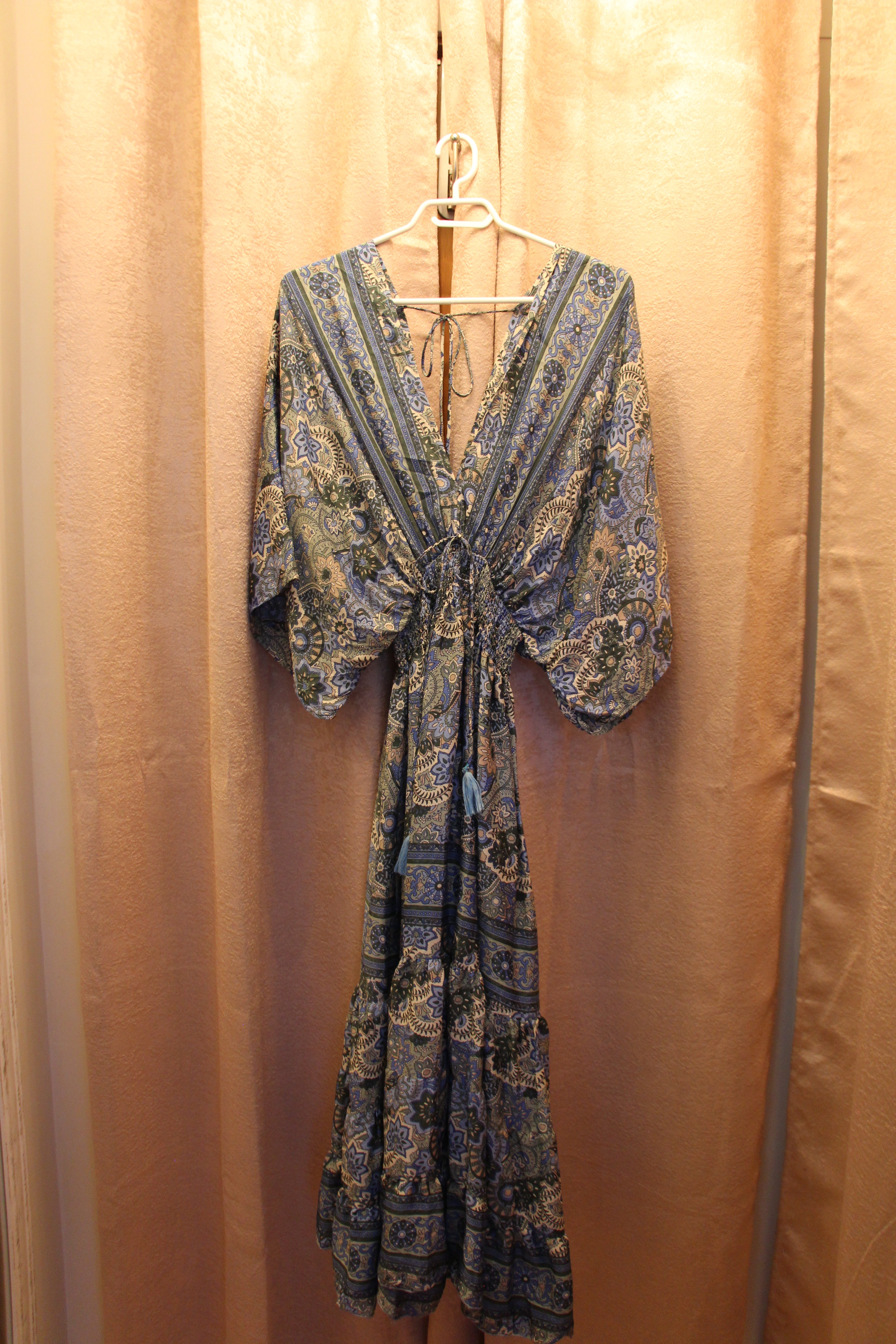 A consignment boutique  long-sleeve maxi dress with a blue, green, and beige paisley pattern, by Bold and Beautiful  this Art Silk Roper Dress  has elasticized shirring. 