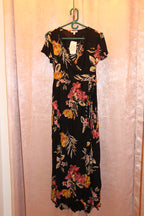 A consignment boutique black maxi dress with a vibrant floral print in pink, yellow, and orange, NWT Size S Patrons of Peace Black Floral Short Sleeve Maxi Dress.