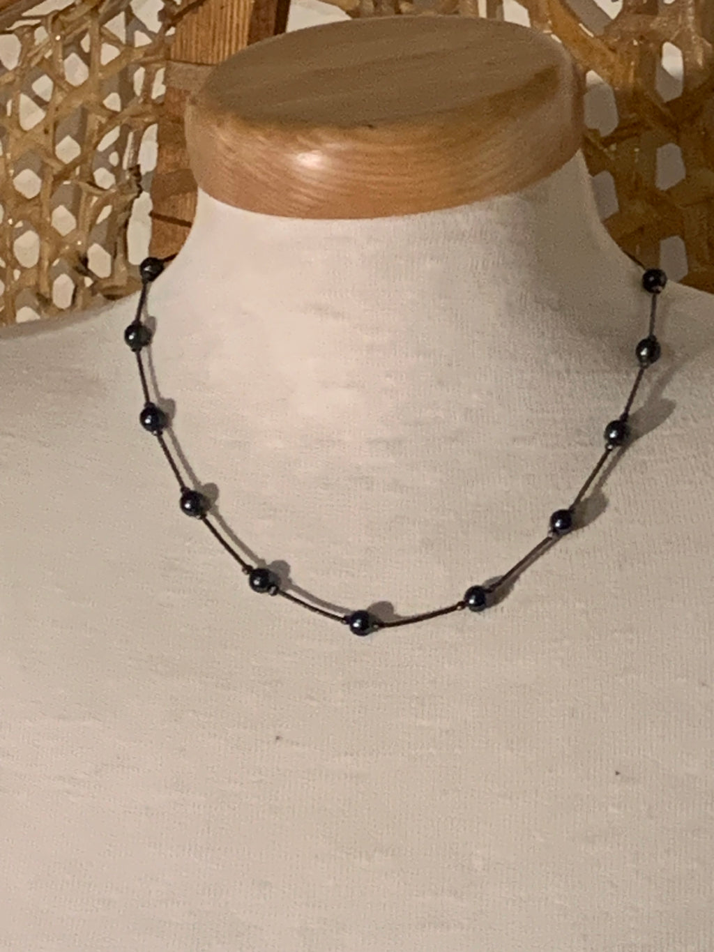 Featuring evenly spaced dark iridescent beads (resembling gunmetal, dark faux pearl, or hematite) strung along a delicate metallic snake chain with a secure lobster claw clasp