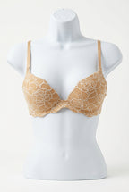 Beige lace bra on a mannequin on consignment.